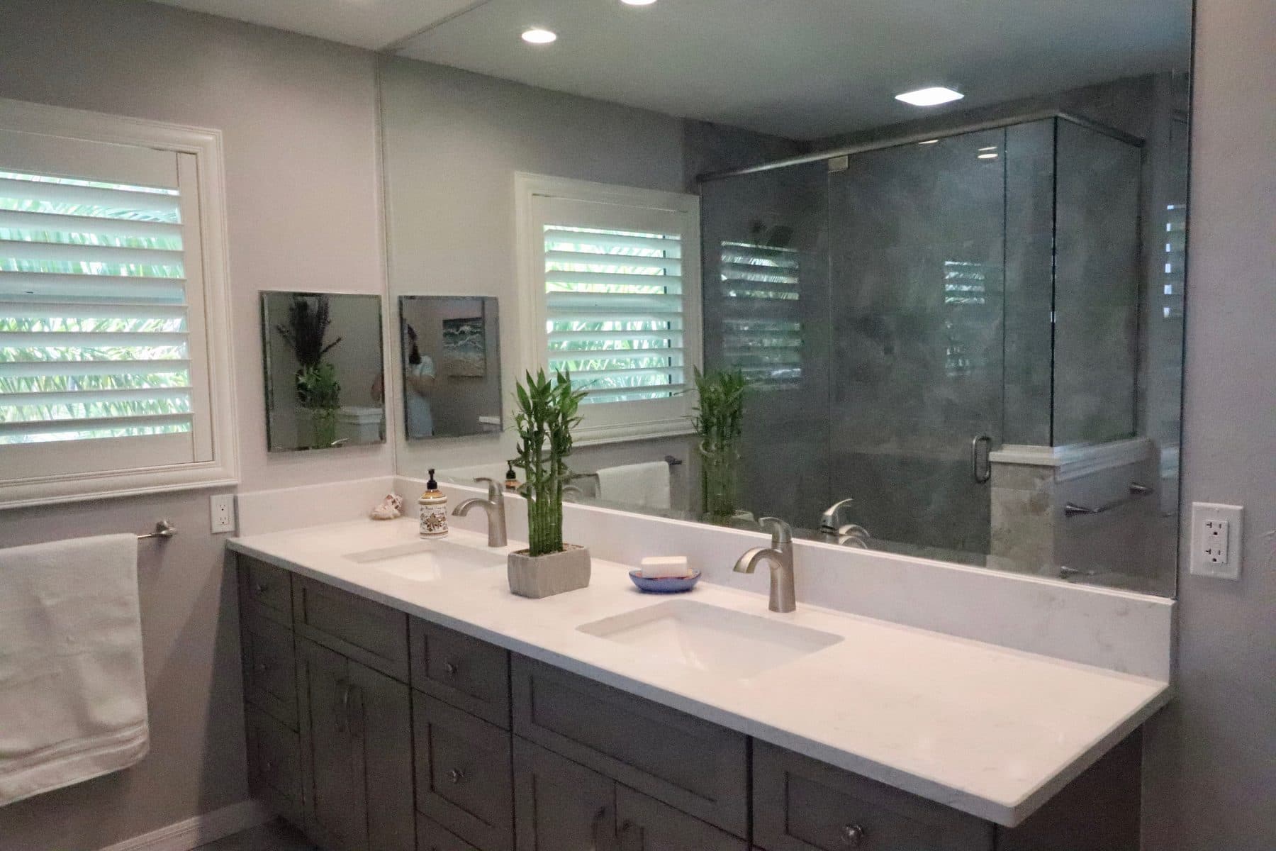 Finished bathroom with double vanity and glass shower