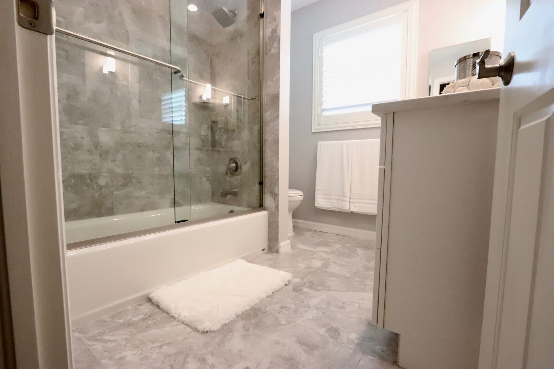 Finished bathroom with glass shower and subway tile