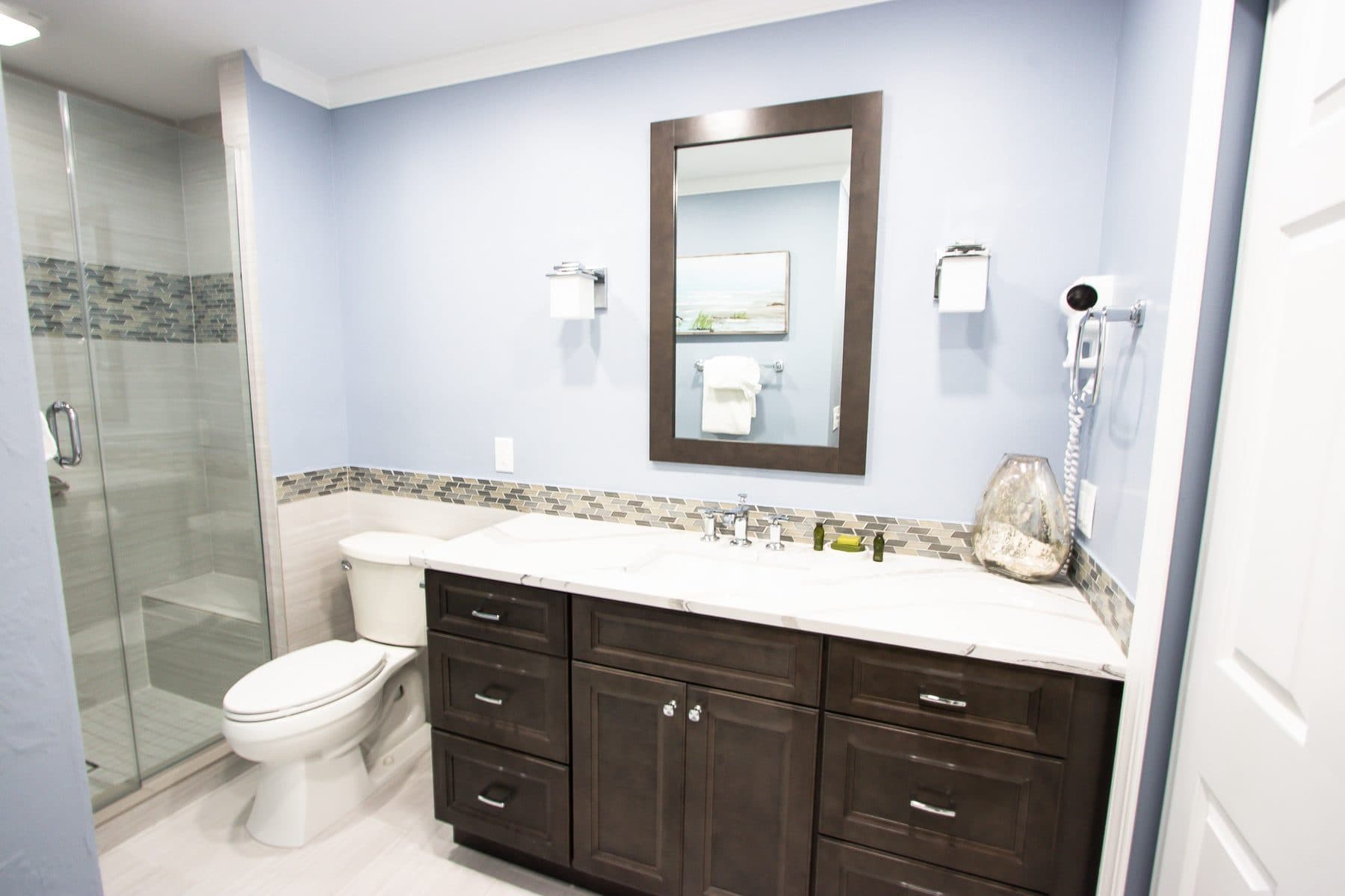 Finished bathroom with dark cabinetry and blue walls