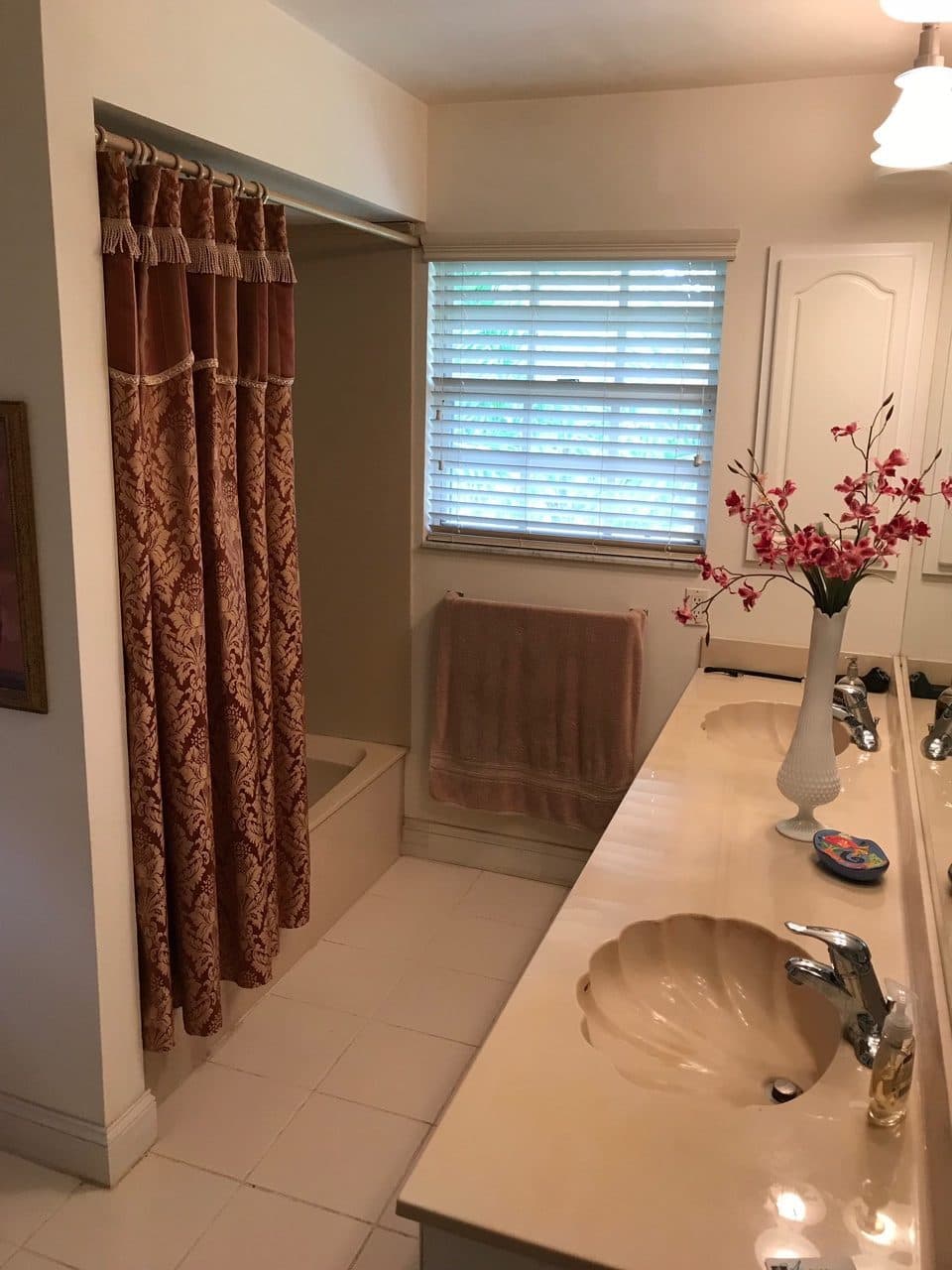 Dated bathroom with red curtain and vanity