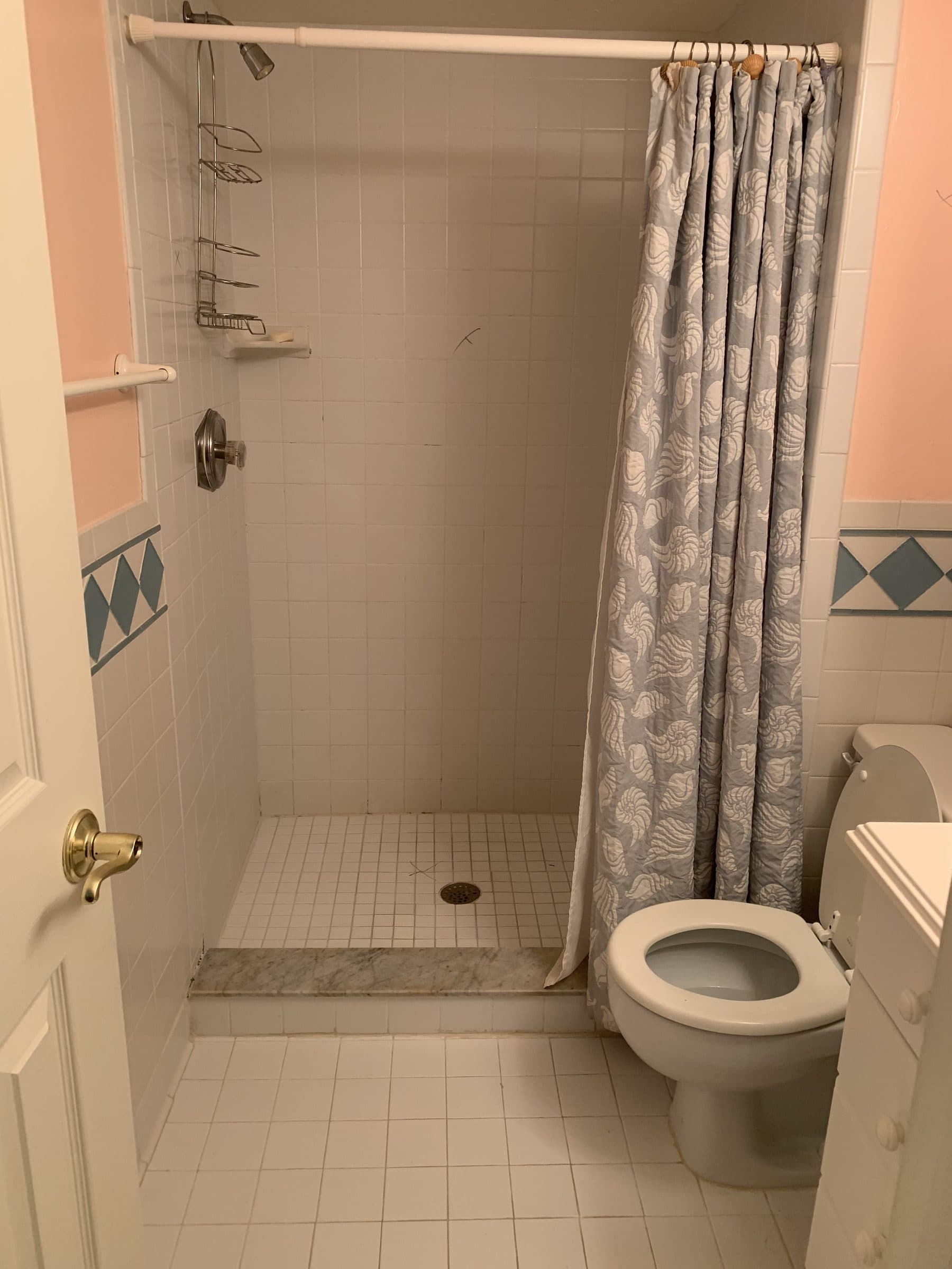 Dated bathroom with diamond-pattern tile shower curtain
