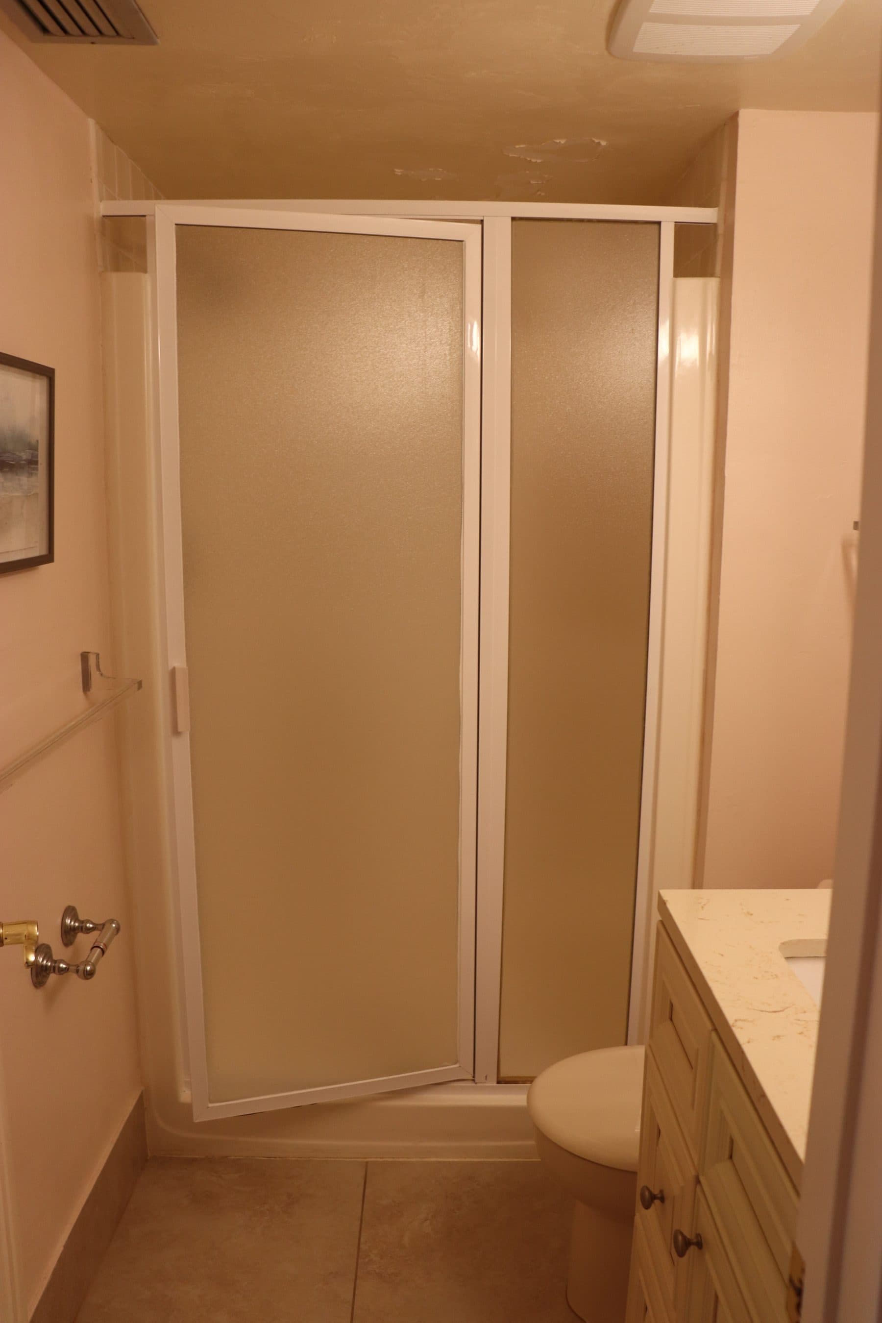 Dated bathroom with tan sliding shower doors