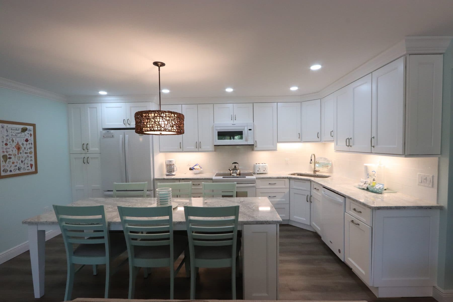 Finished white kitchen with island and pendant lighting