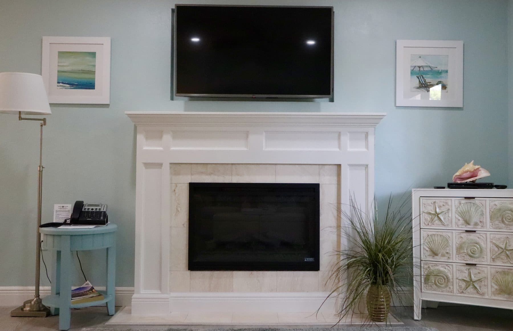 White mantel fireplace in a coastal living room