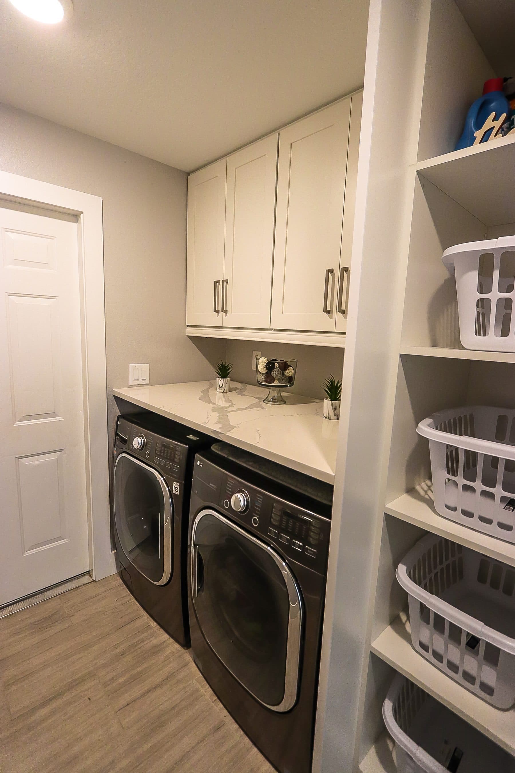 Laundry room with white cabinetry and door