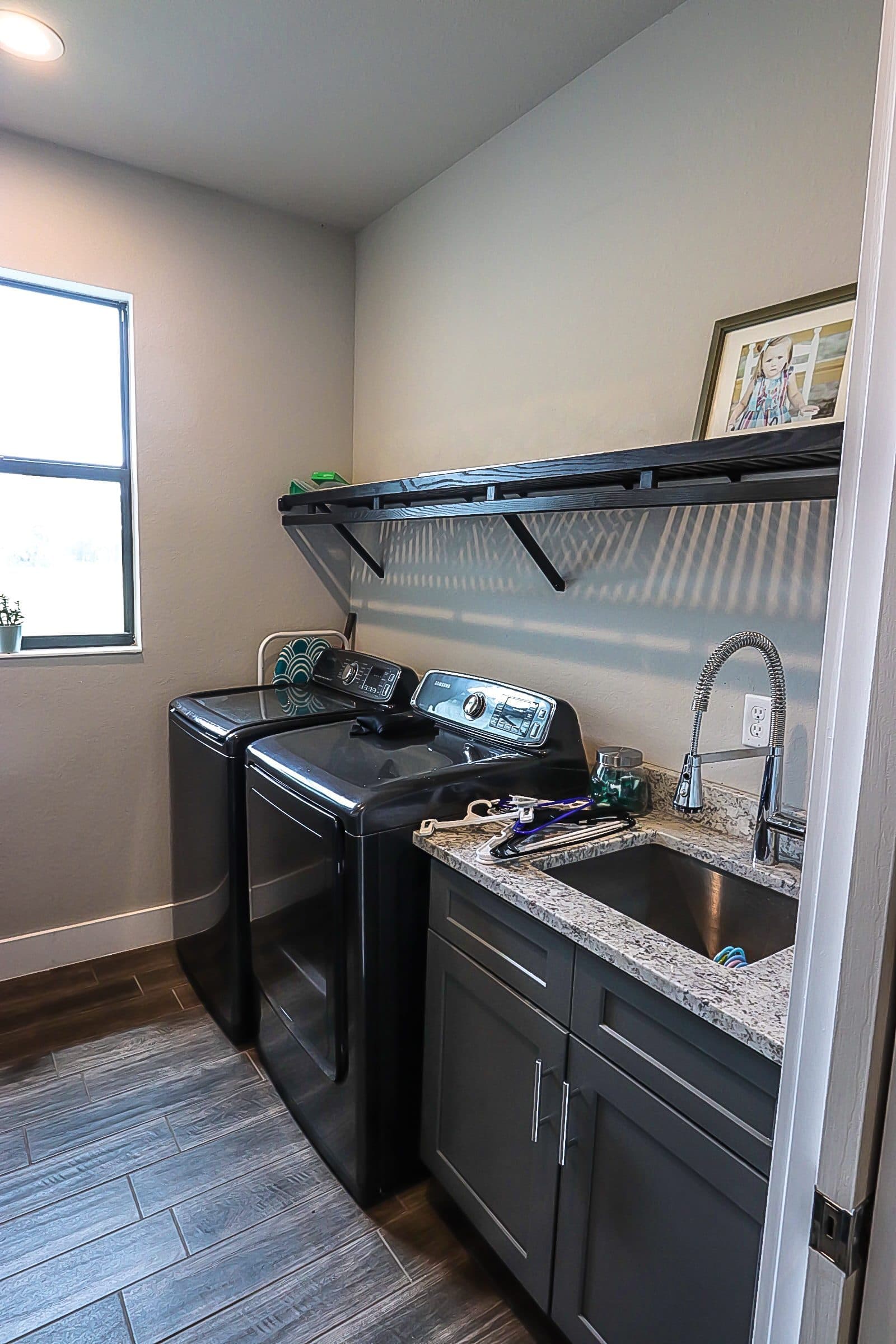 Laundry room with dark cabinetry and sink