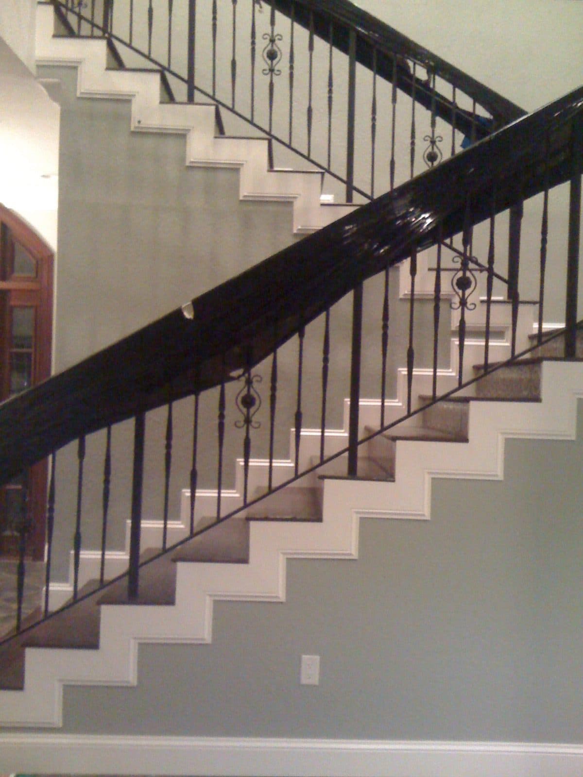 Contemporary staircase with black railing and white risers