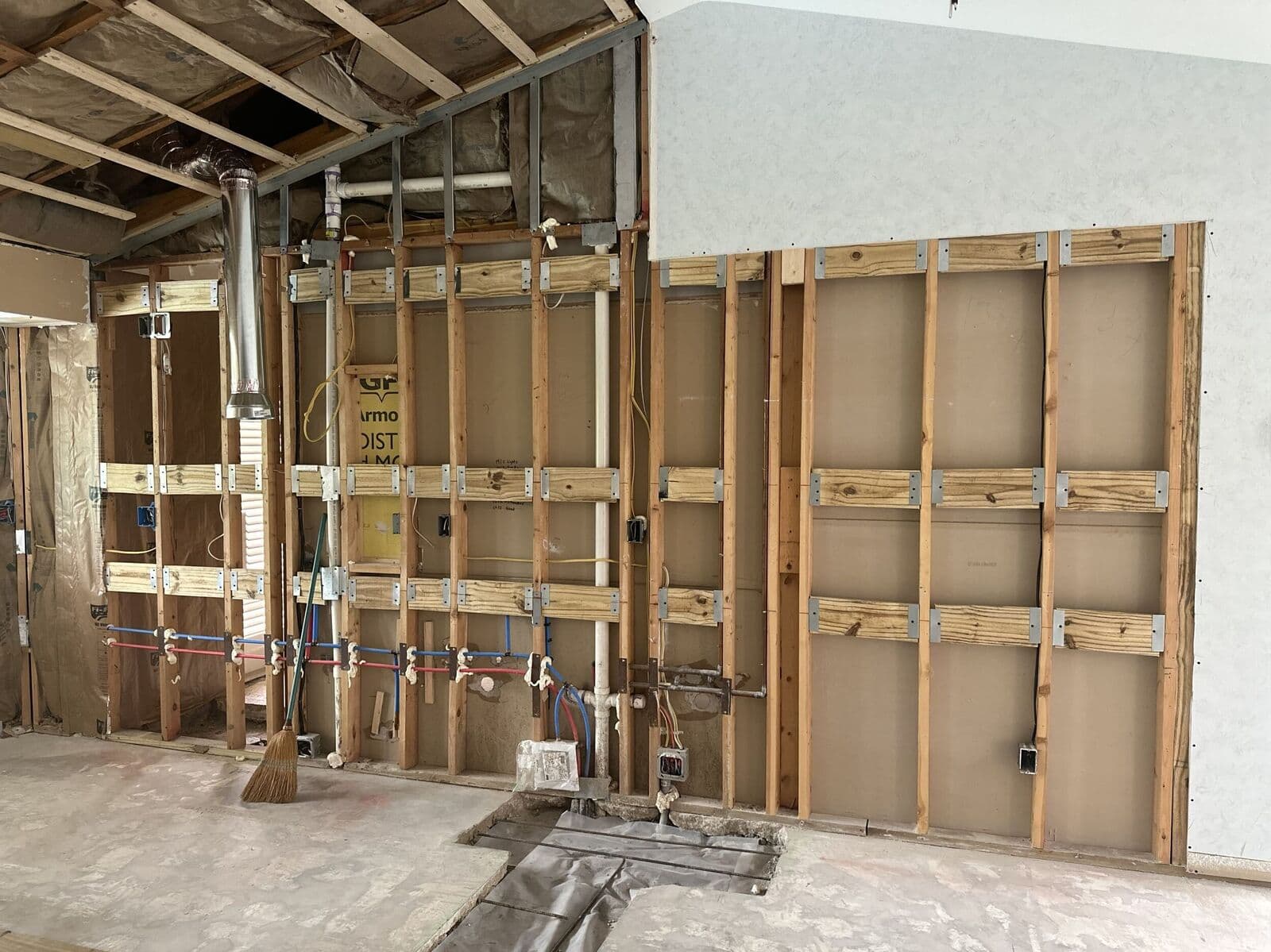 Wall opened up to the studs with new framing and plumbing supply lines roughed in