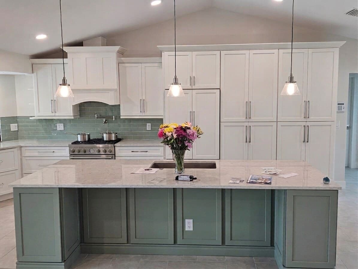 Wide view of the finished kitchen and island under a vaulted ceiling